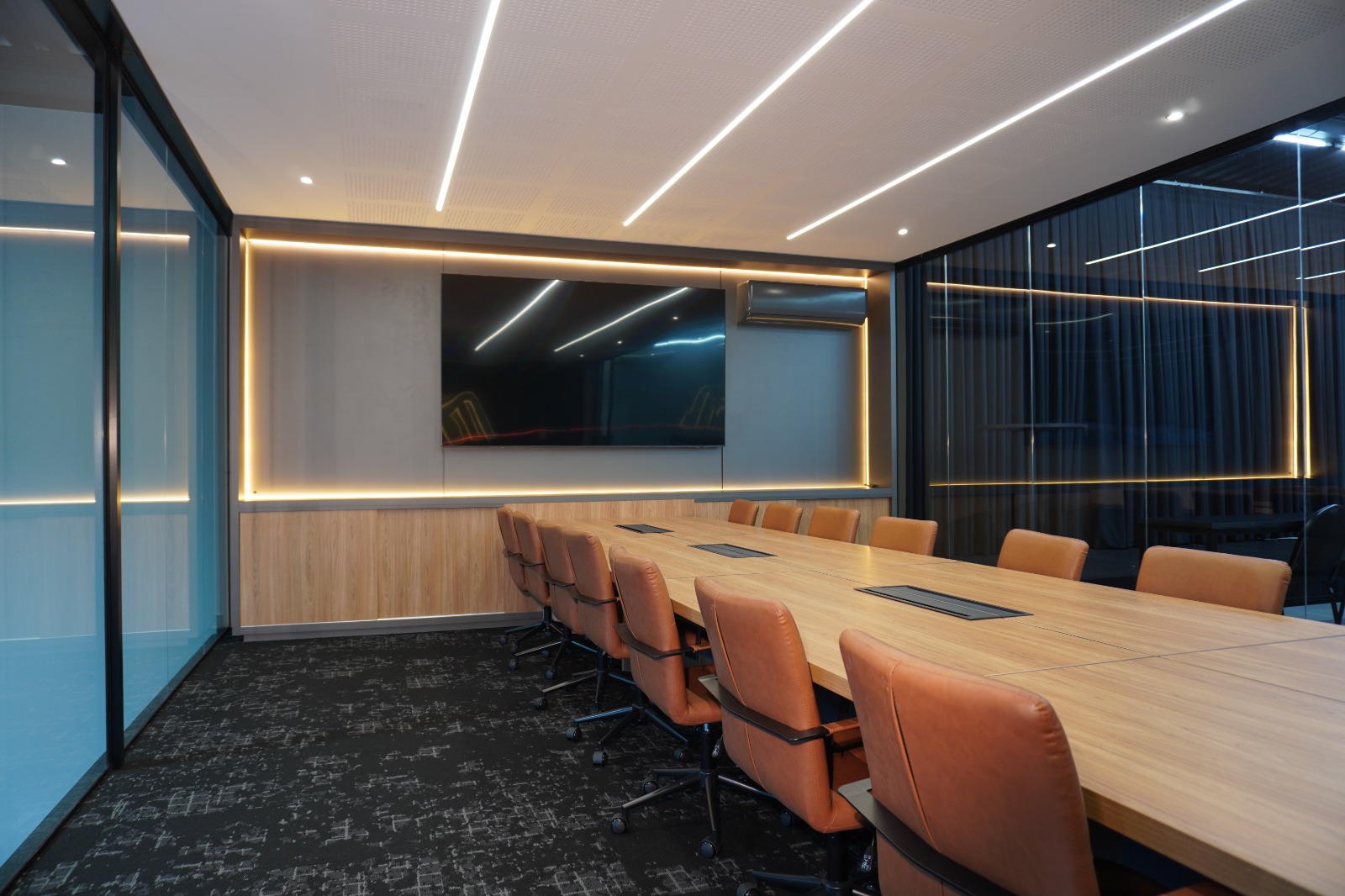 Sala de reunião corporativa com mesa ampla e cadeiras em couro